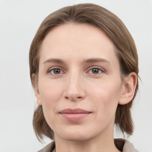 Joyful white young-adult female with medium  brown hair and grey eyes