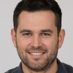 Joyful white adult male with short  brown hair and brown eyes