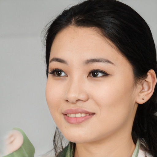 Joyful asian young-adult female with long  black hair and brown eyes