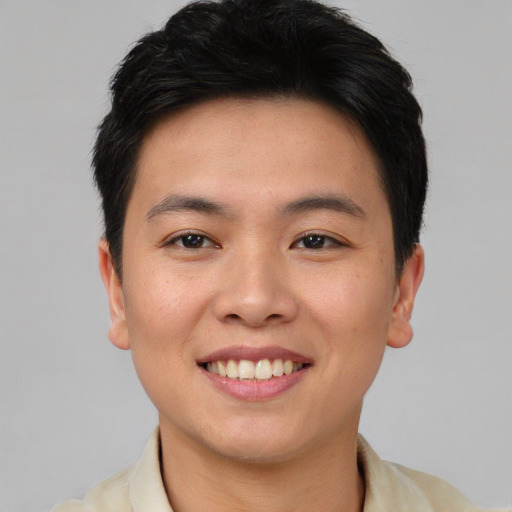 Joyful asian young-adult male with short  brown hair and brown eyes