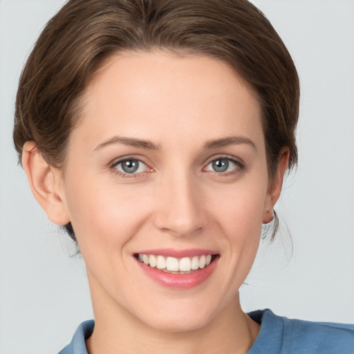 Joyful white young-adult female with medium  brown hair and grey eyes