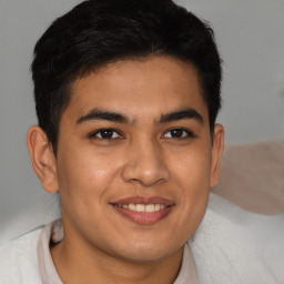 Joyful latino young-adult male with short  brown hair and brown eyes