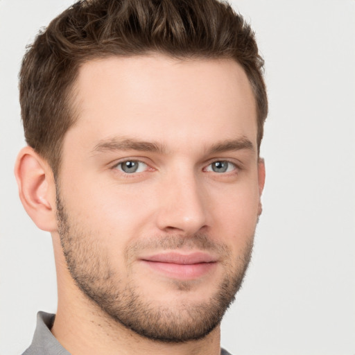 Joyful white young-adult male with short  brown hair and grey eyes