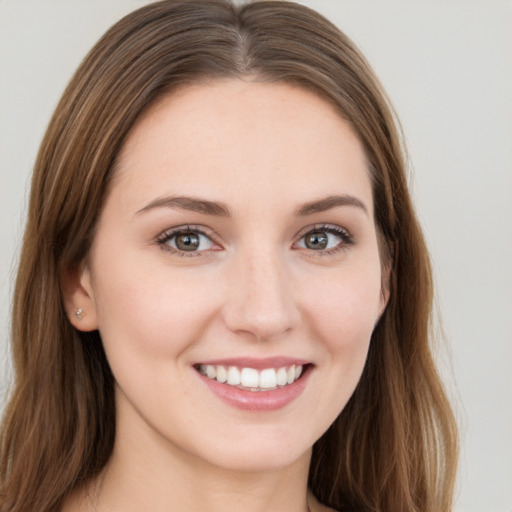 Joyful white young-adult female with long  brown hair and green eyes