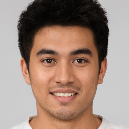 Joyful white young-adult male with short  black hair and brown eyes