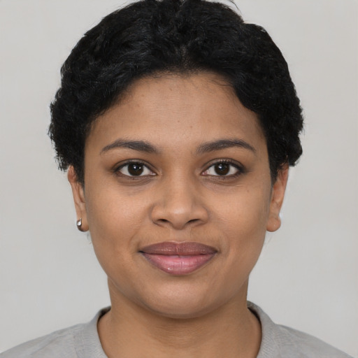Joyful black young-adult female with short  black hair and brown eyes