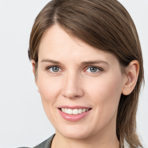 Joyful white young-adult female with medium  brown hair and grey eyes