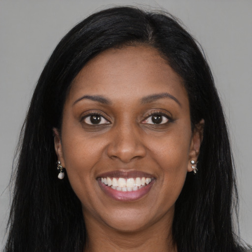 Joyful black young-adult female with long  brown hair and brown eyes