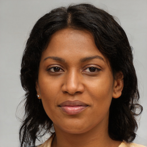 Joyful black young-adult female with long  brown hair and brown eyes