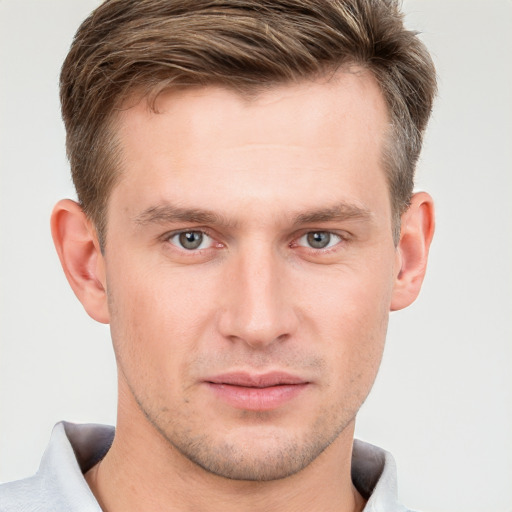 Joyful white young-adult male with short  brown hair and grey eyes