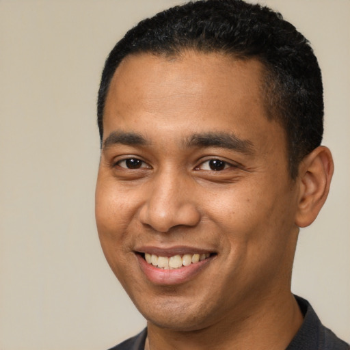 Joyful latino young-adult male with short  brown hair and brown eyes