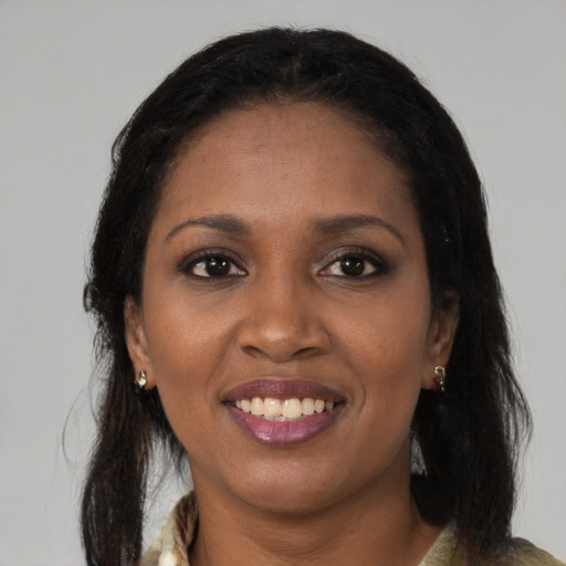 Joyful black young-adult female with long  brown hair and brown eyes