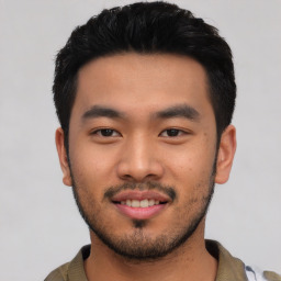 Joyful asian young-adult male with short  black hair and brown eyes