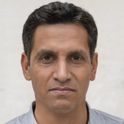 Joyful white adult male with short  black hair and brown eyes