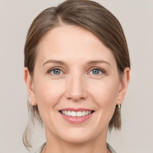 Joyful white adult female with medium  brown hair and grey eyes