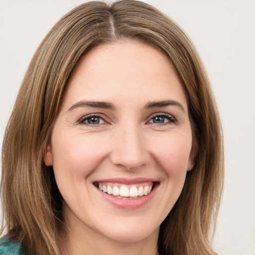 Joyful white young-adult female with long  brown hair and green eyes