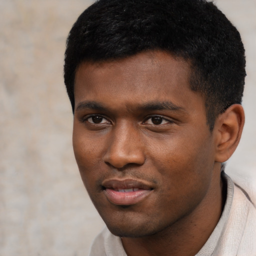 Joyful black young-adult male with short  black hair and brown eyes