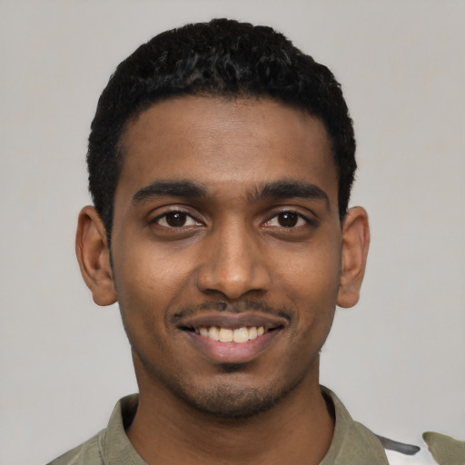 Joyful black young-adult male with short  black hair and brown eyes