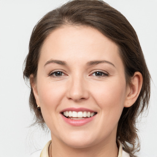 Joyful white young-adult female with medium  brown hair and grey eyes