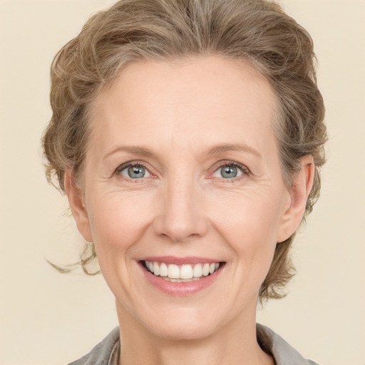 Joyful white adult female with medium  brown hair and grey eyes