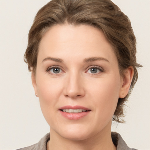 Joyful white young-adult female with medium  brown hair and grey eyes