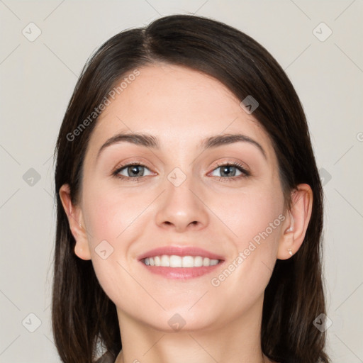 Joyful white young-adult female with long  brown hair and grey eyes