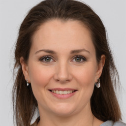 Joyful white adult female with long  brown hair and grey eyes