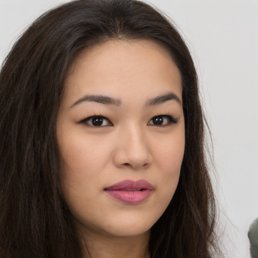 Joyful asian young-adult female with long  brown hair and brown eyes
