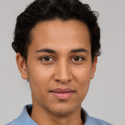 Joyful latino young-adult male with short  brown hair and brown eyes