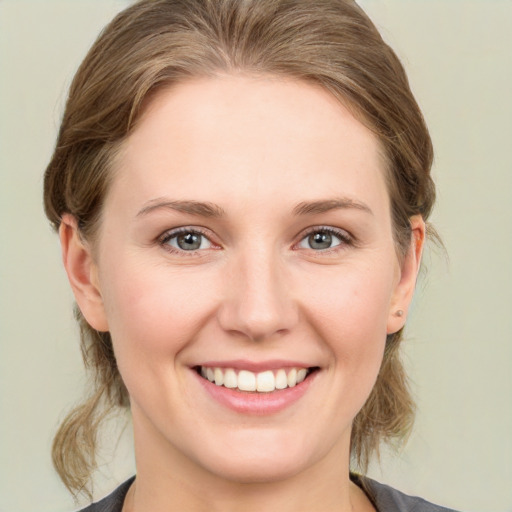 Joyful white young-adult female with medium  brown hair and grey eyes