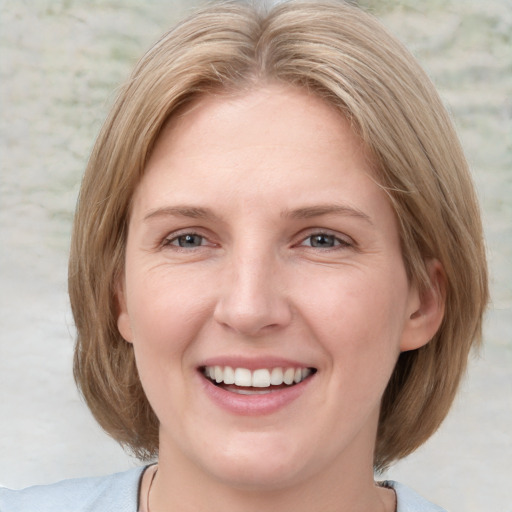 Joyful white young-adult female with medium  brown hair and blue eyes