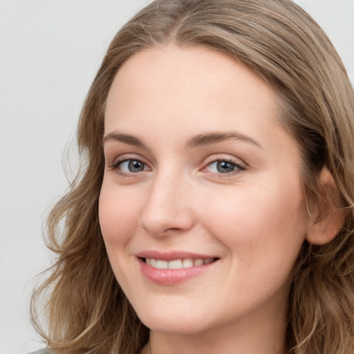 Joyful white young-adult female with long  brown hair and blue eyes