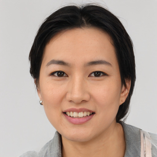 Joyful asian young-adult female with medium  black hair and brown eyes