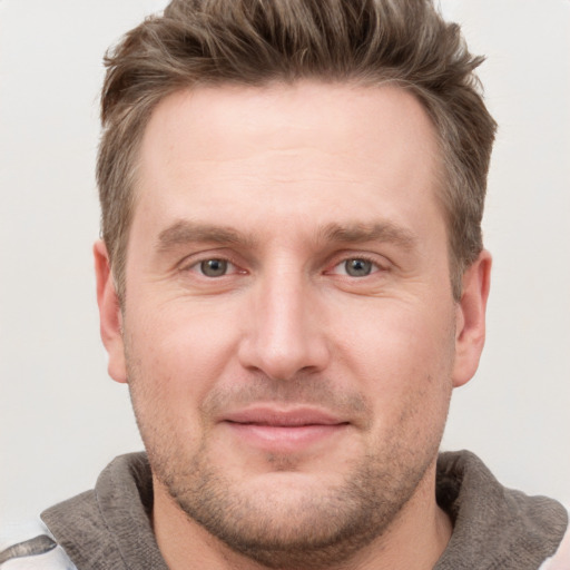 Joyful white young-adult male with short  brown hair and grey eyes