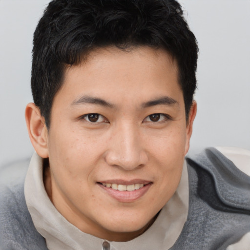 Joyful asian young-adult male with short  brown hair and brown eyes