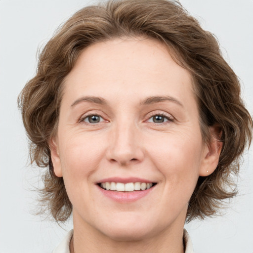 Joyful white adult female with medium  brown hair and grey eyes