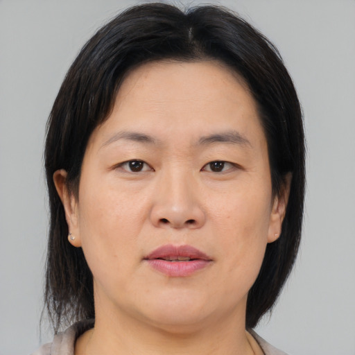 Joyful asian adult female with medium  brown hair and brown eyes