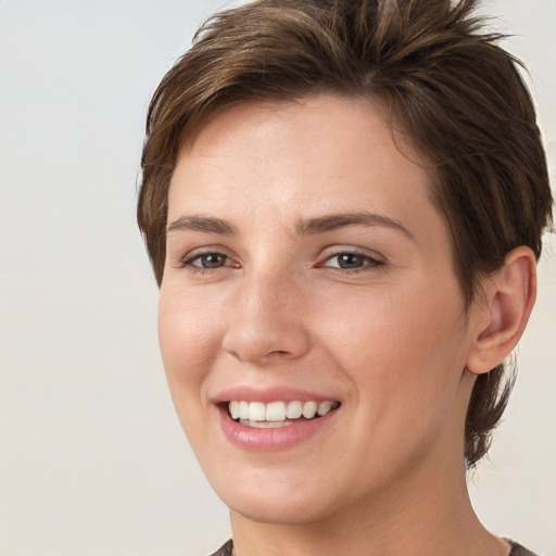 Joyful white young-adult female with short  brown hair and grey eyes