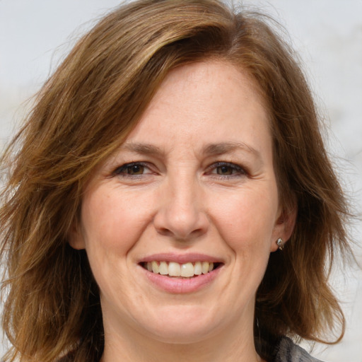 Joyful white adult female with medium  brown hair and brown eyes