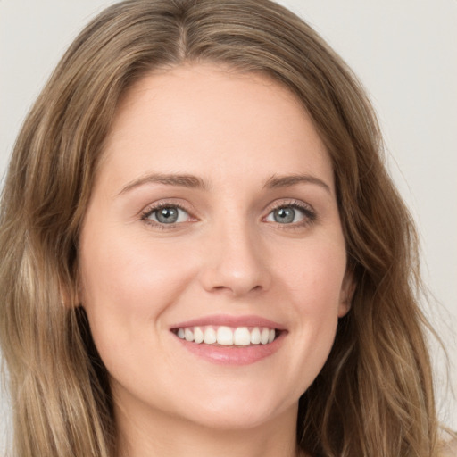 Joyful white young-adult female with long  brown hair and green eyes