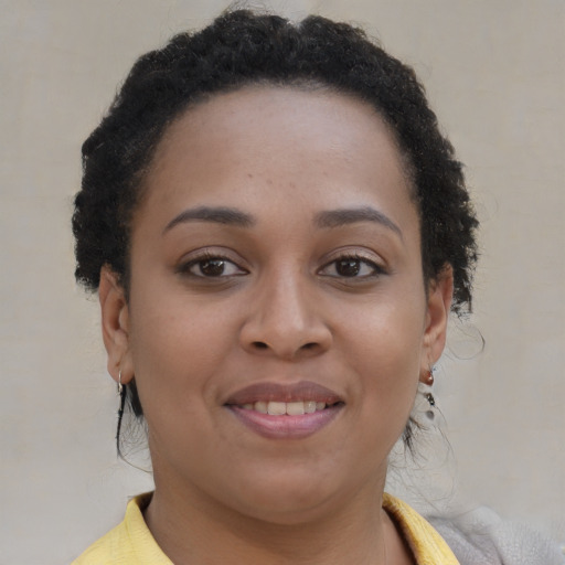 Joyful black young-adult female with short  brown hair and brown eyes