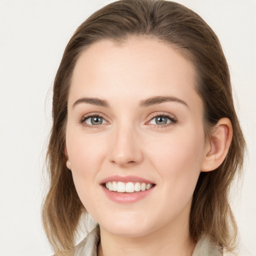 Joyful white young-adult female with medium  brown hair and grey eyes