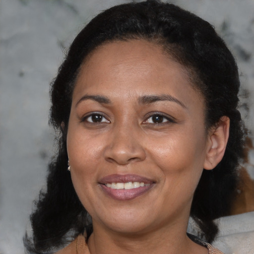Joyful black adult female with medium  brown hair and brown eyes