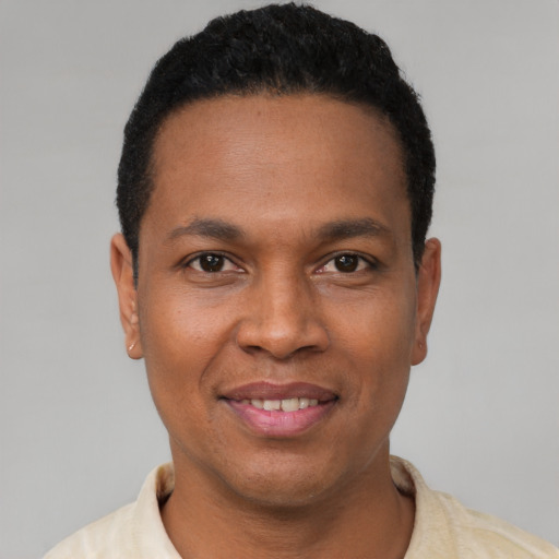 Joyful latino young-adult male with short  black hair and brown eyes