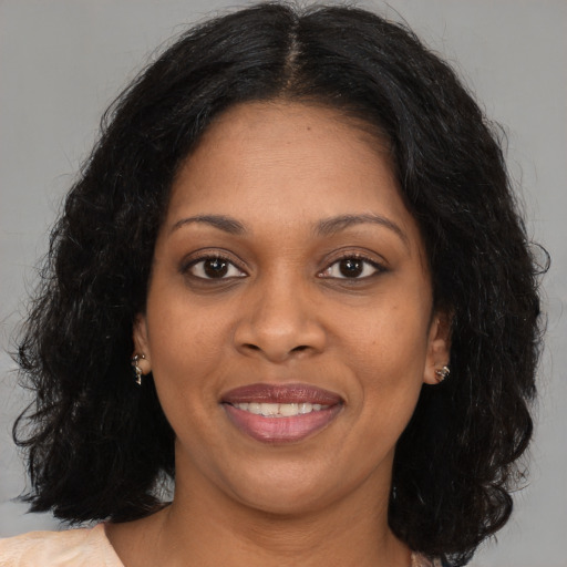 Joyful black young-adult female with long  brown hair and brown eyes