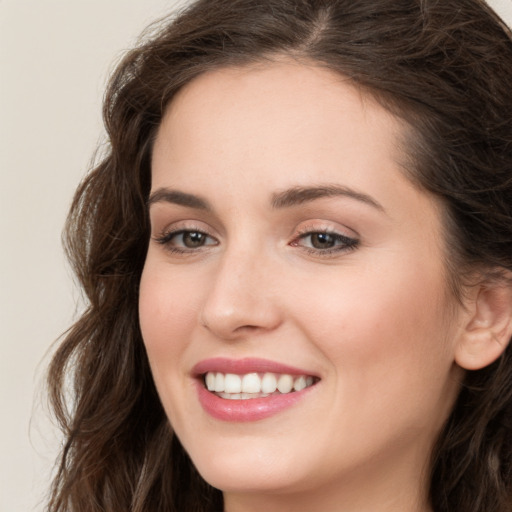 Joyful white young-adult female with long  brown hair and green eyes