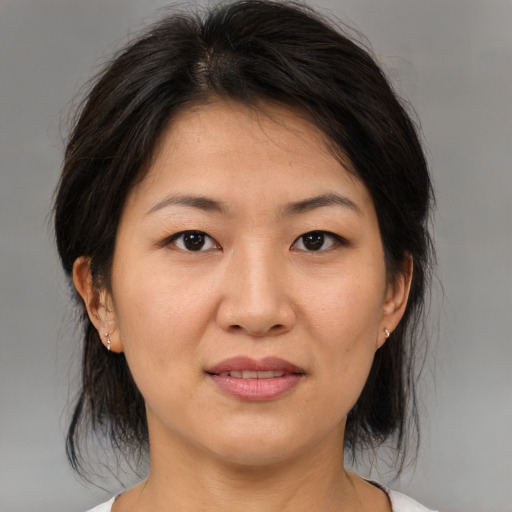Joyful asian young-adult female with medium  brown hair and brown eyes