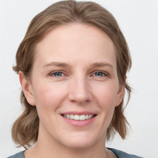 Joyful white young-adult female with medium  brown hair and blue eyes