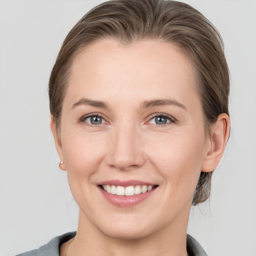 Joyful white young-adult female with medium  brown hair and grey eyes