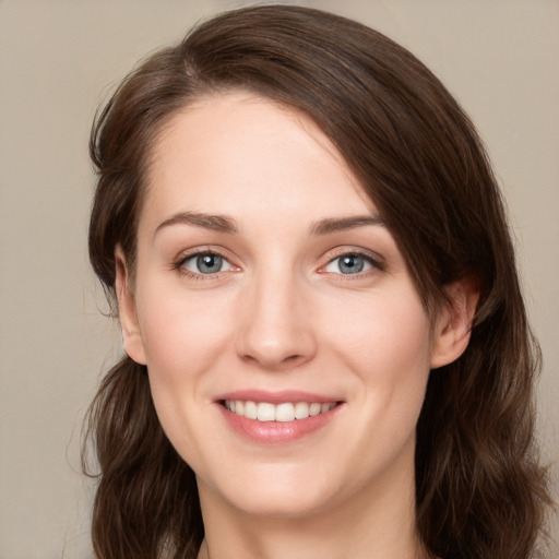 Joyful white young-adult female with long  brown hair and green eyes